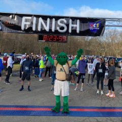 FeLeap the Frog mascot at starting line with racers standing behind