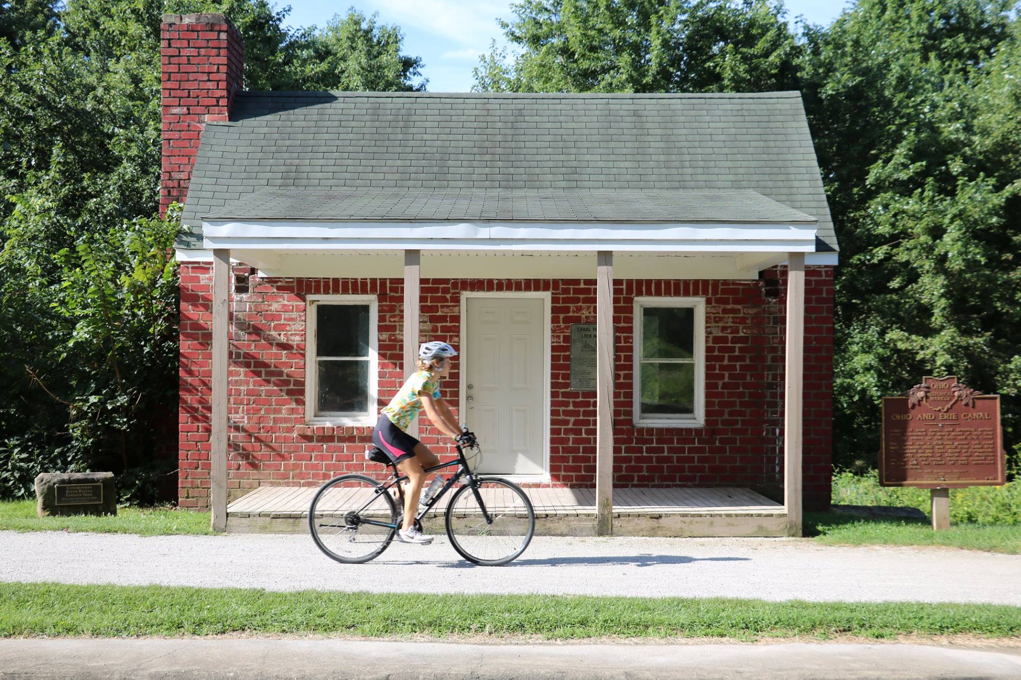 Biker riding on trail with cabin in background
