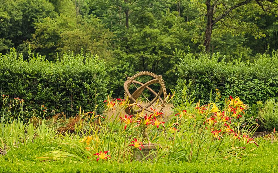 Sun Dial in Garden with flowers blooming