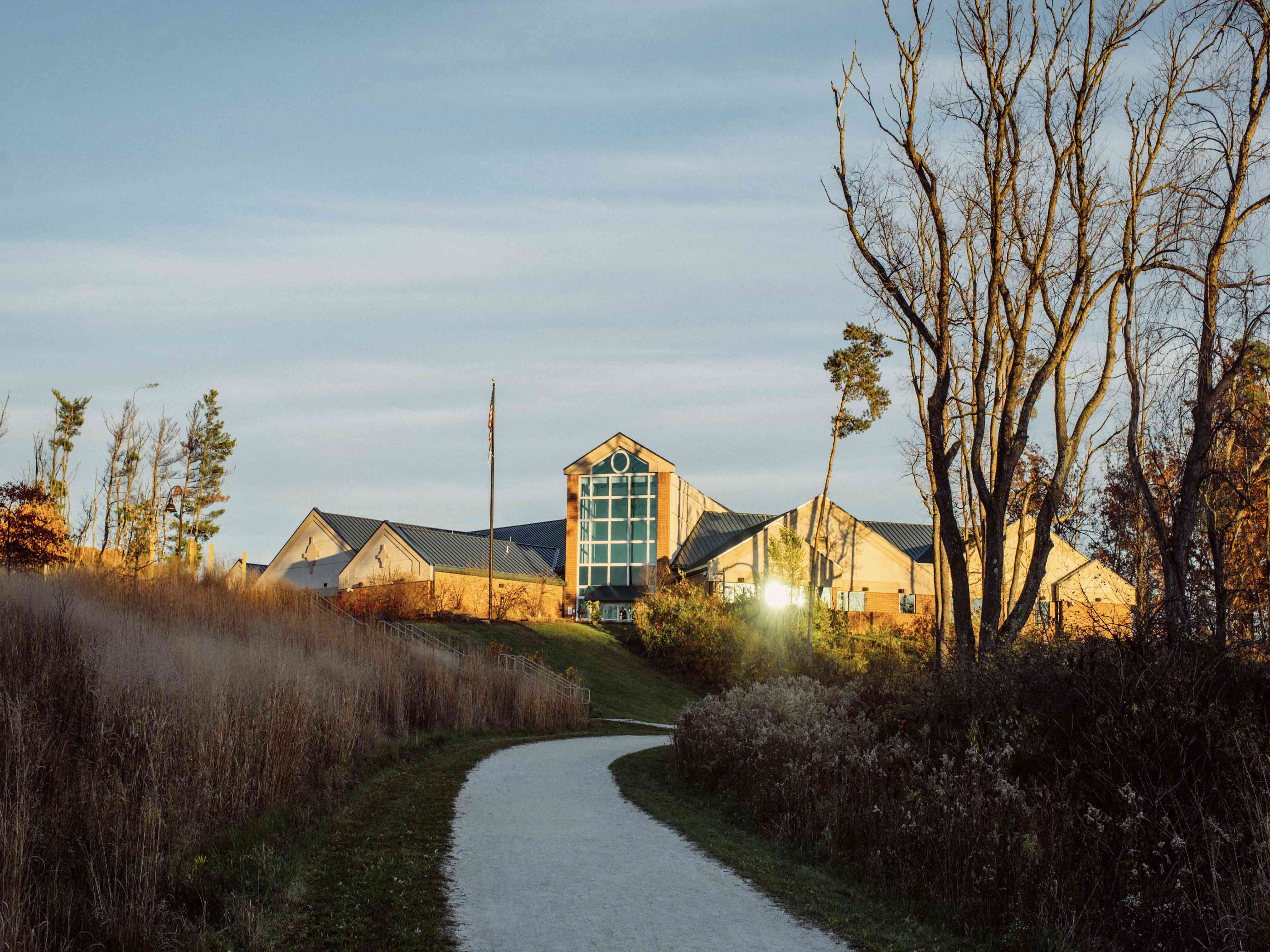 Trail winding around turn with Exploration Gateway facility in distance