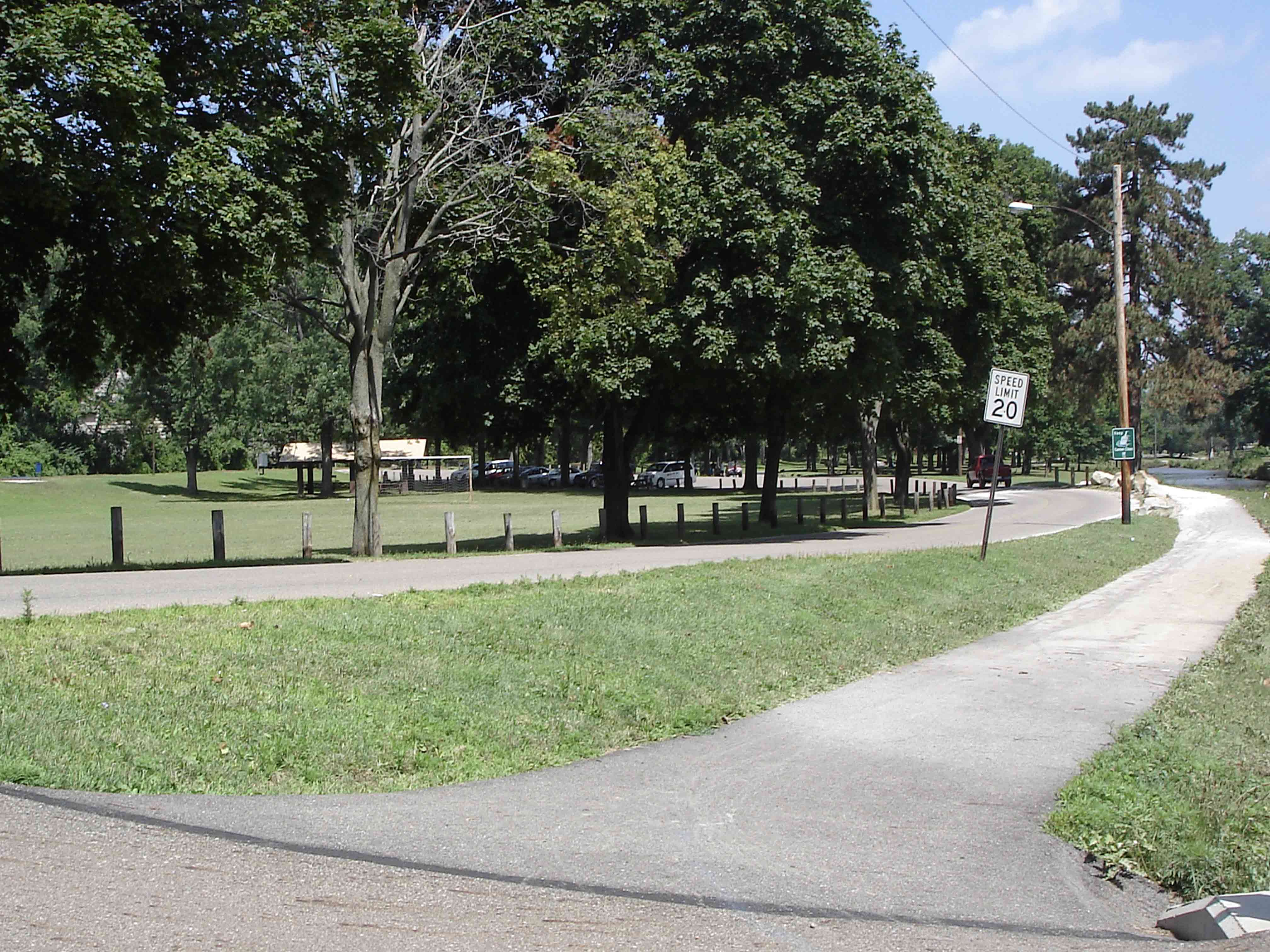 Trail traveling between creek and parkway road