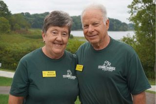 couple smiling with lake in background